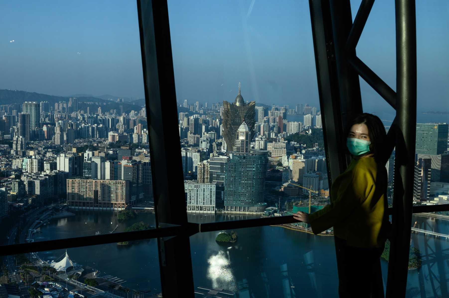 A woman wears a facemask as she poses for a photo at the observation deck of Macau Tower on Jan 30, 2020. Photo: AFP 