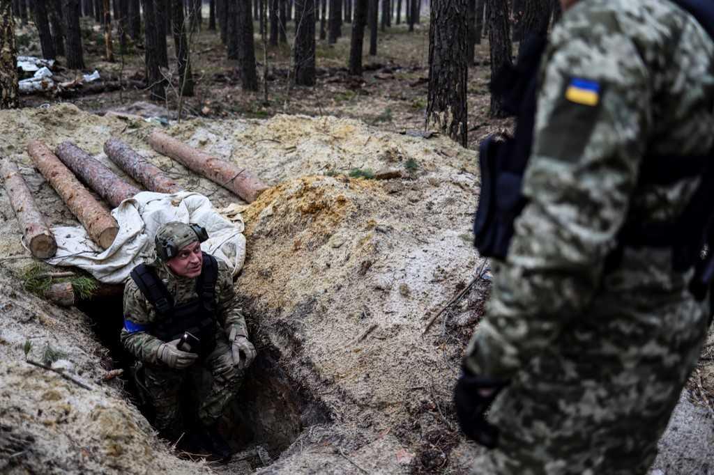 A member of the Ukrainian army check a trench in an empty Russian base camp near Buda-Babynetska, north of Kyiv, on April 5. Photo: AFP