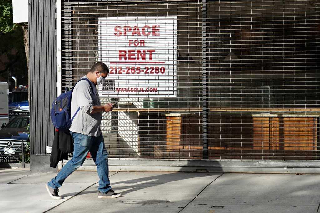 A man wearing a protective mask walks by a closed café on Oct 19, 2020 in New York City. Photo: AFP