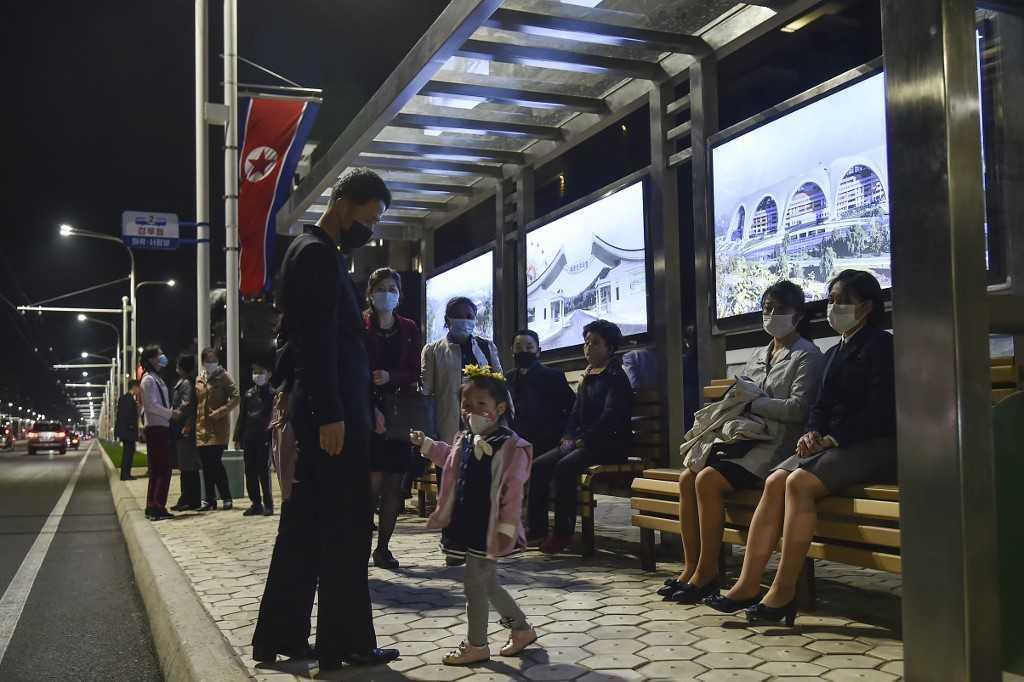 In this photo taken on April 16, people wait for a trolleybus at a bus stop in the newly built residential area of Kyongru-Dong, in the Central District of Pyongyang. Photo: AFP