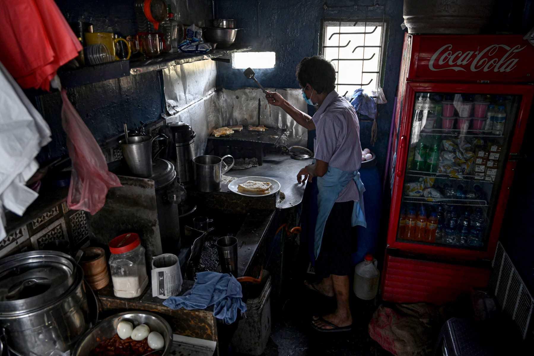 A food vendor prepares food at his shop after a power cut in Colombo on March 2. Photo: AFP