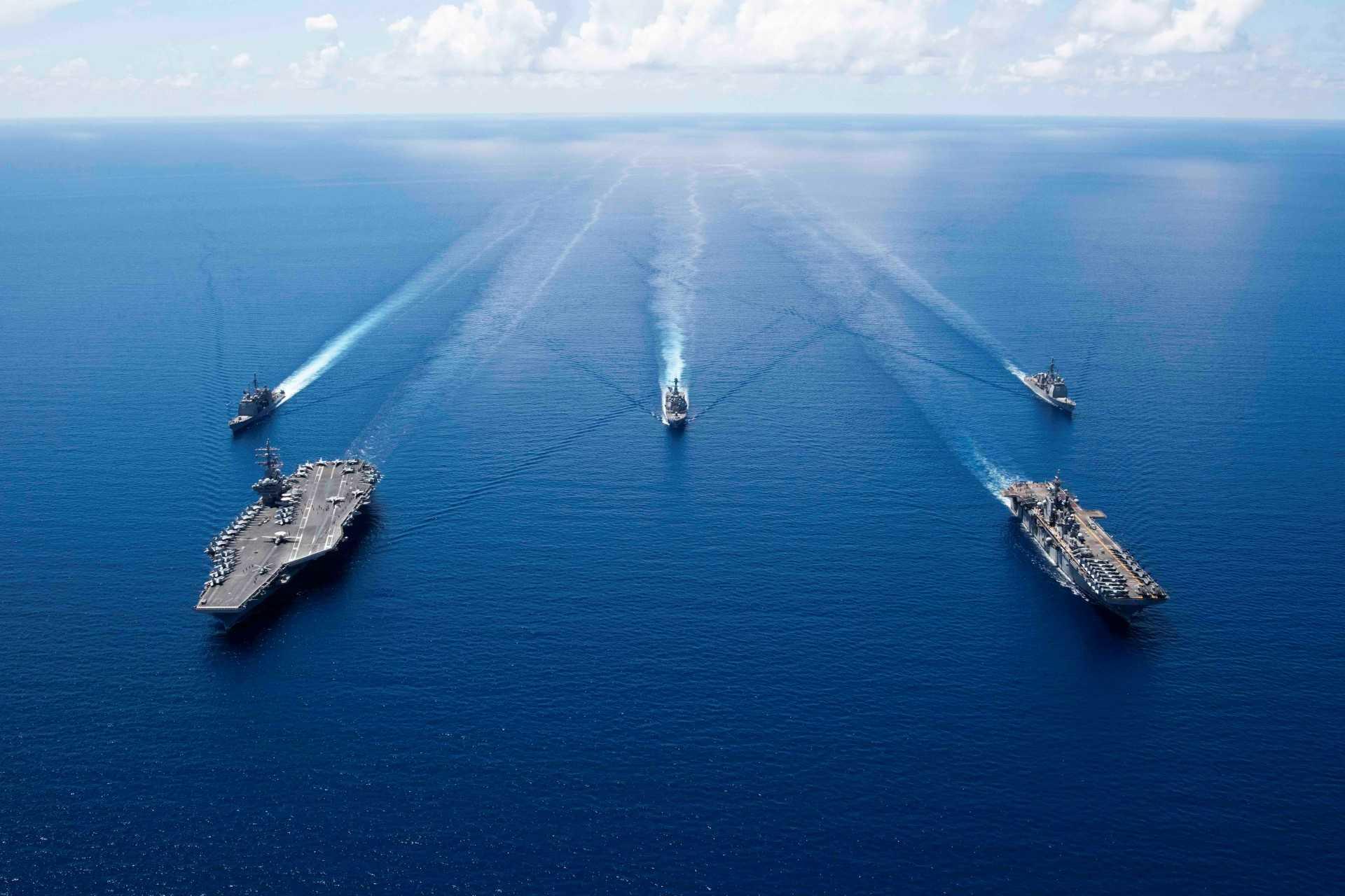 This US Navy photo obtained Oct 7, 2019 shows the aircraft carrier USS Ronald Reagan (CVN 76)(L), and the amphibious assault ship USS Boxer (LHD 6) and ships from the Ronald Reagan Carrier Strike Group and the Boxer Amphibious Ready Group underway in formation while conducting security and stability operations in the US 7th Fleet area of operations on Oct 6, 2019 in the South China Sea. Photo: AFP 