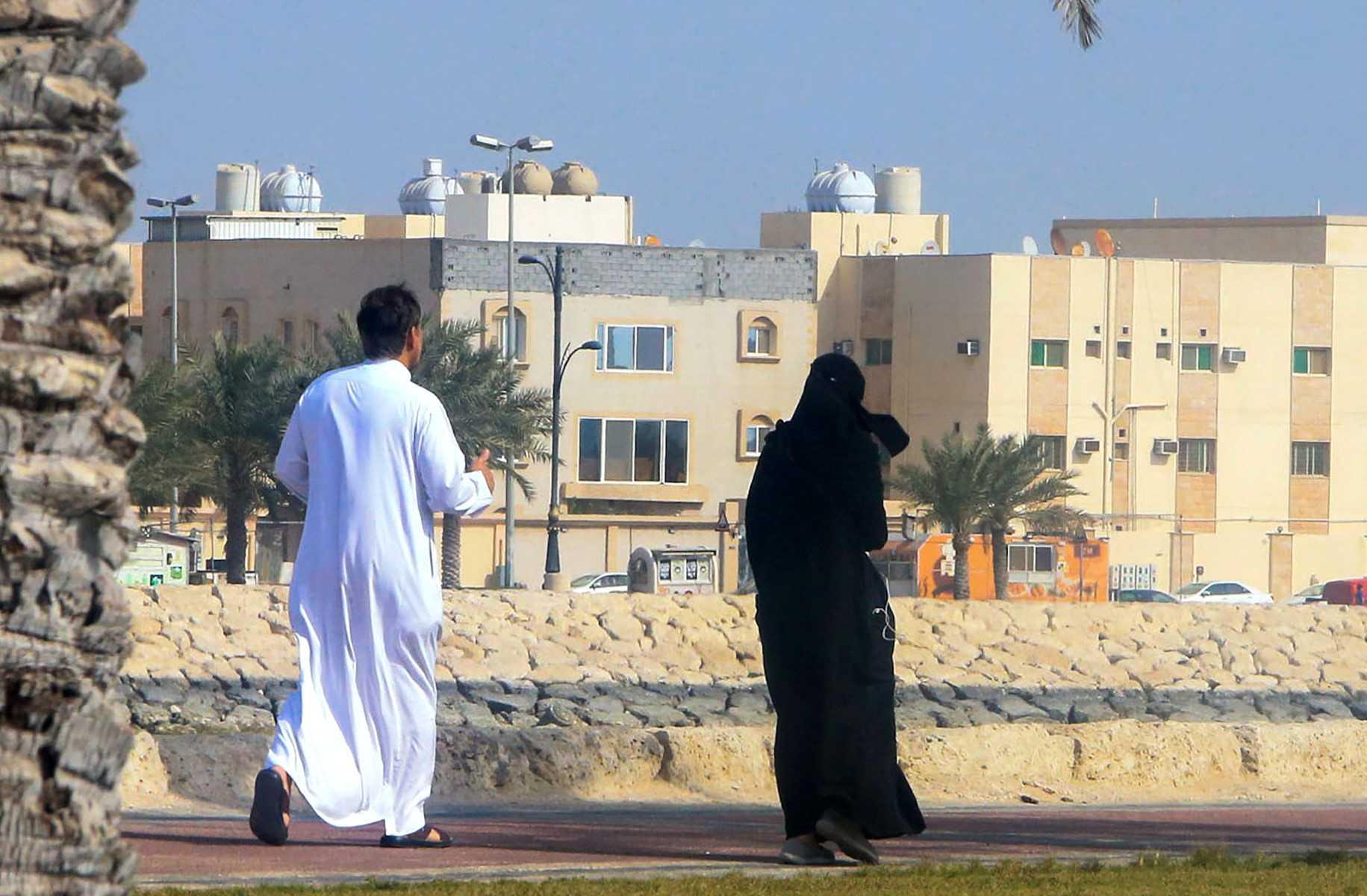 A couple takes a stroll on a sidewalk in Qatif city in Saudi Arabia's Eastern Province, some 400Km from the capital Riyadh, on March 9, 2020. Photo: AFP 