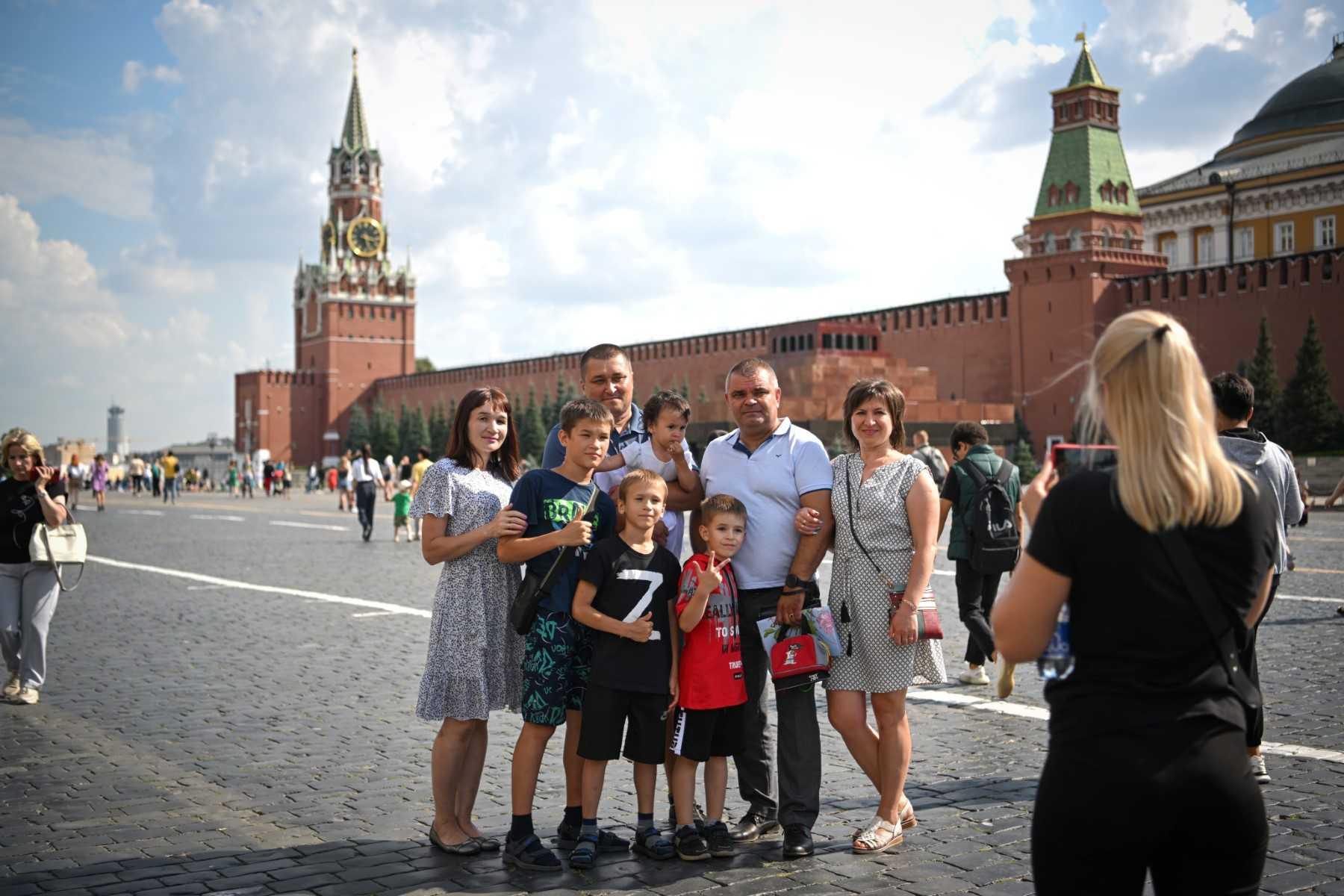 A group of people, including a boy wearing a T-shirt with the letter Z, which has become a symbol of support for Russian military action in Ukraine, poses for pictures on Red Square in downtown Moscow on July 25. Photo: AFP