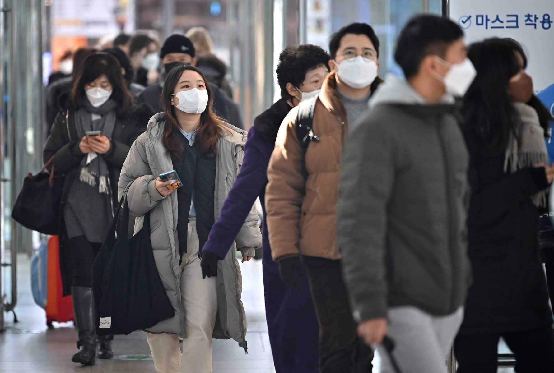 People wearing face masks walk through a railway station in Seoul on Feb 18. Photo: AFP