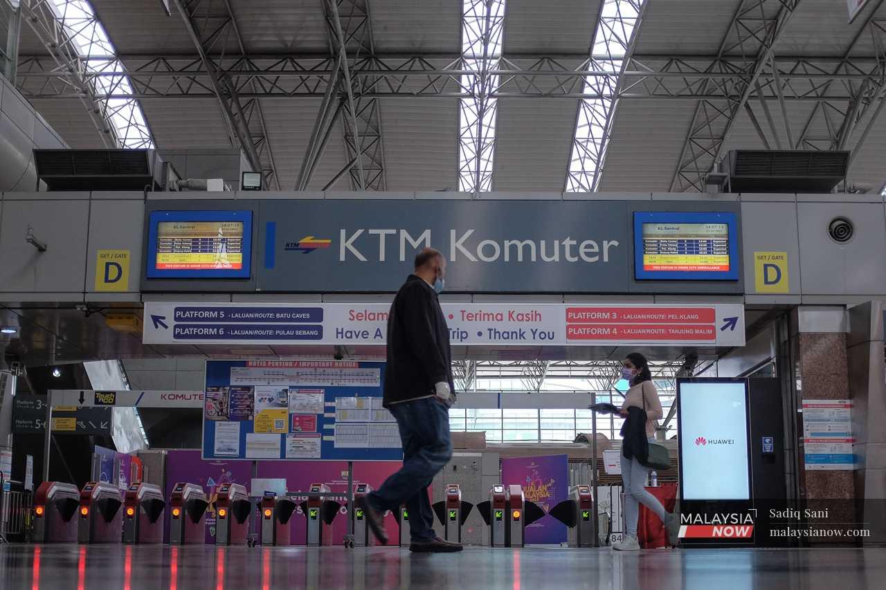 Penumpang berjalan melepasi pintu masuk KTM Komuter di KL Sentral, stesen pusat yang menghubung semua perkhidmatan tren dalam bandar dan antara negeri.