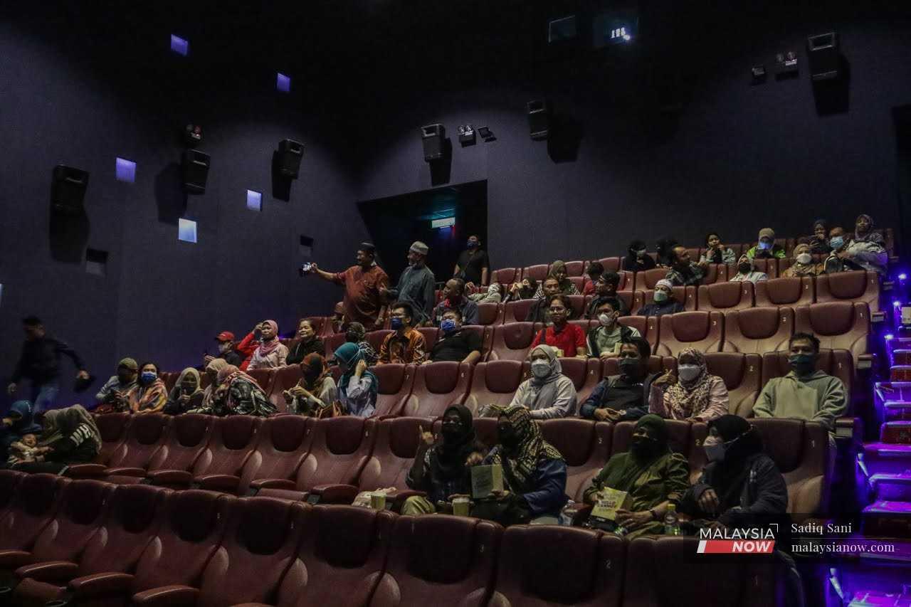 Peminat duduk di kerusi mereka dalam pawagam di Kuala Lumpur bagi menonton filem 'Mat Kilau: Kebangkitan Pahlawan'. Aktiviti menonton filem di pawagam adalah satu aktiviti biasa namun tidak di Kelantan.