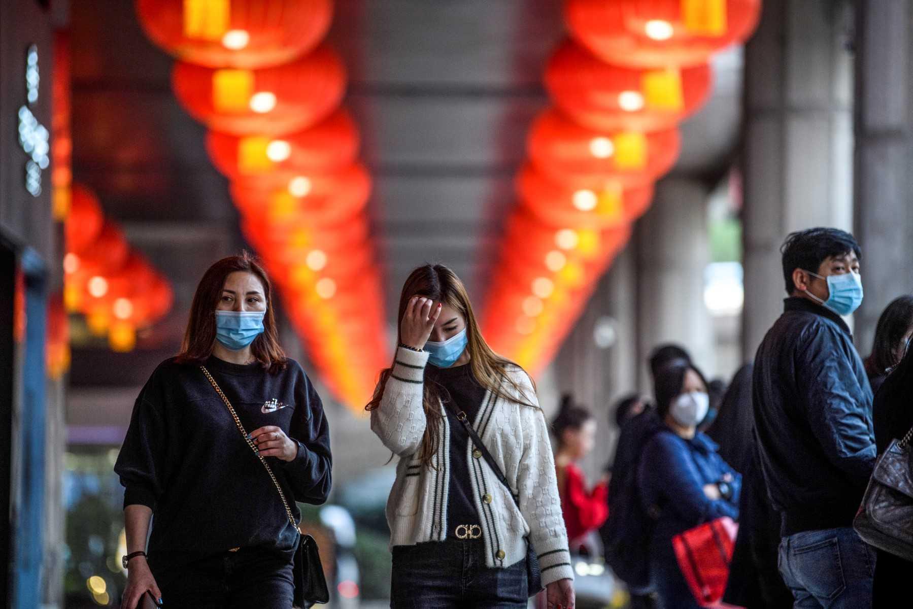 Pedestrians wear face masks as they walk outside the New Orient Landmark hotel in Macau on Jan 22. Photo: AFP
