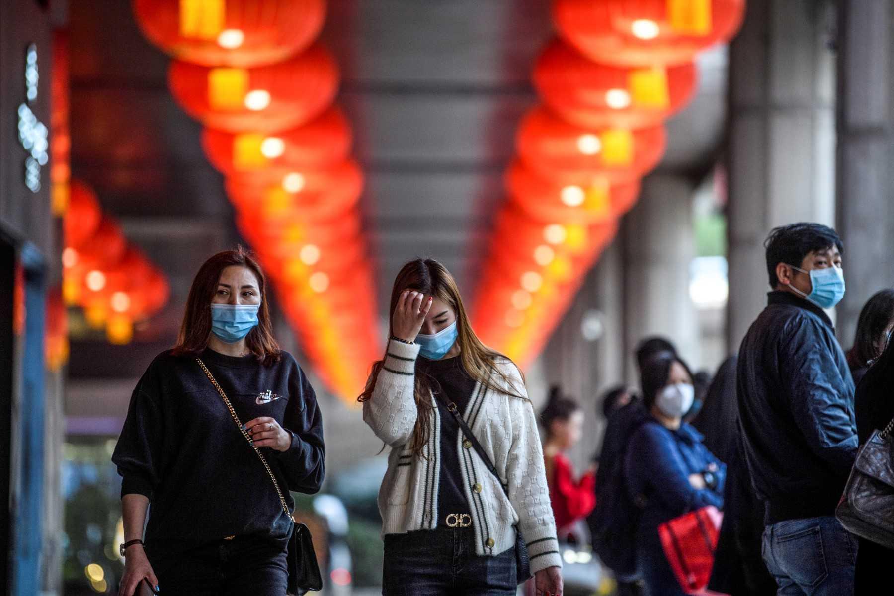 Pedestrians wear face masks as they walk outside the New Orient Landmark hotel in Macau on Jan 22. Photo: AFP 