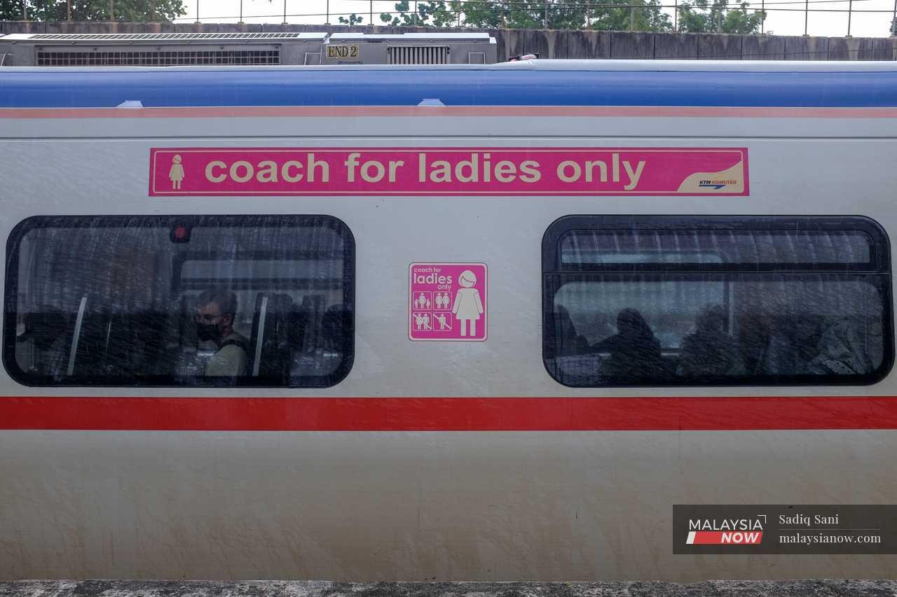 A man looks out the window as he sits in a women’s only coach meant for female passengers. 