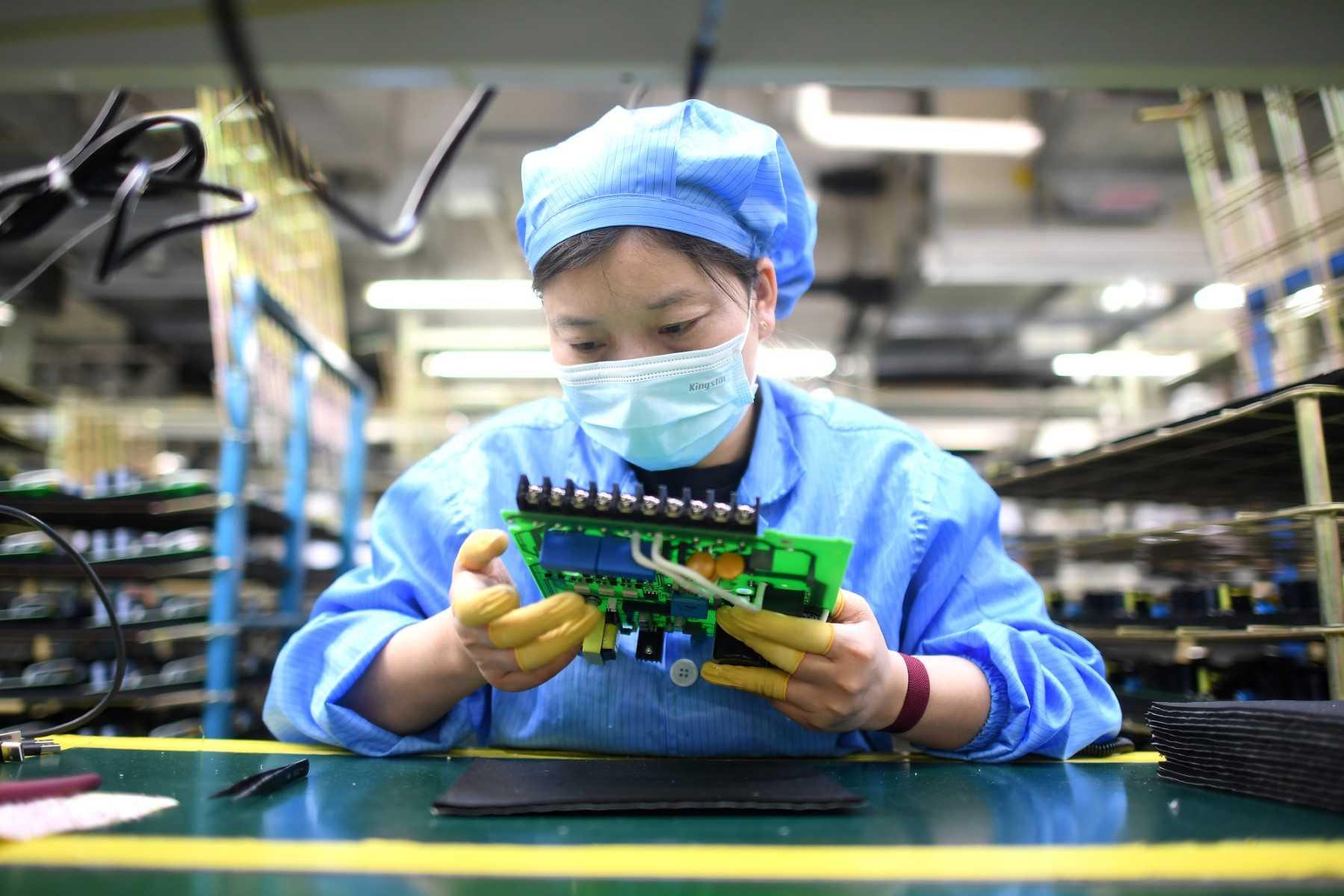 This photo taken on April 13, shows a worker producing industrial robots at a factory in Wuhan, in China's central Hubei province. Photo: AFP