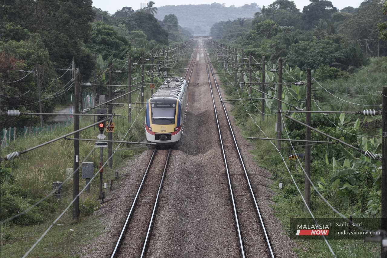 A commuter train moves along the rails after leaving the Tiroi station in Labu, Negeri Sembilan.
