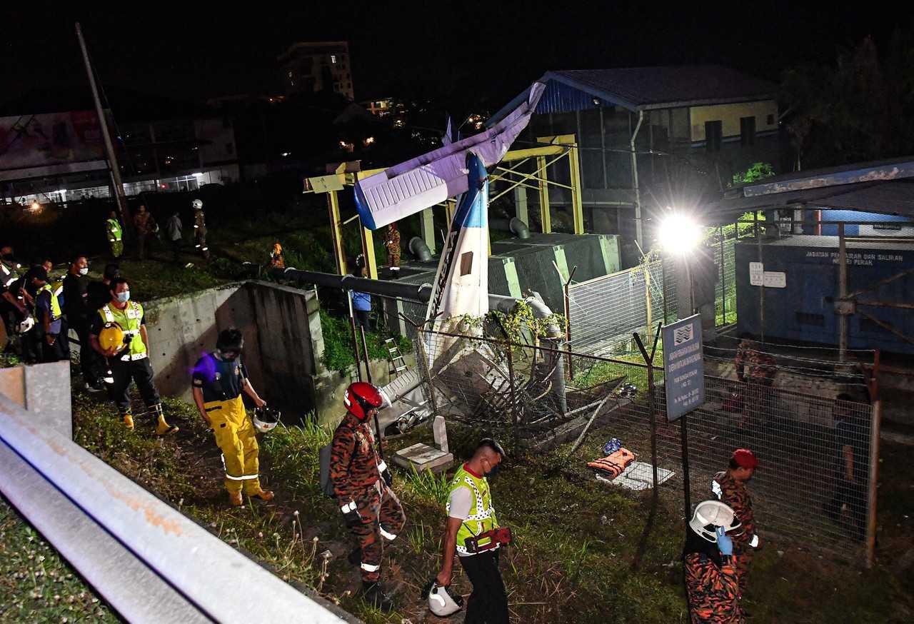 Rescue personnel work at the scene of a light aircraft crash in Medan Gopeng, Ipoh last night. Photo: Bernama
