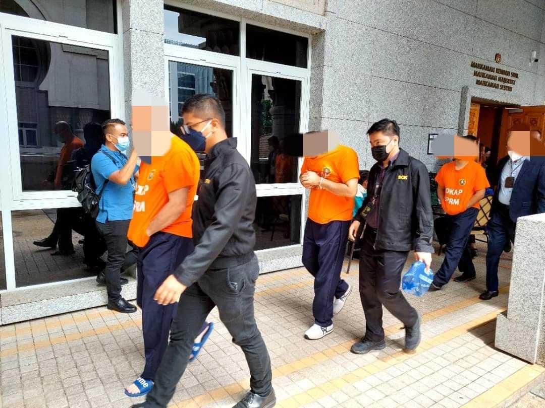Several of the eight suspects arrested in relation to an investigation over bribes for foreign workers at the Magistrate's Court in Putrajaya today. 
