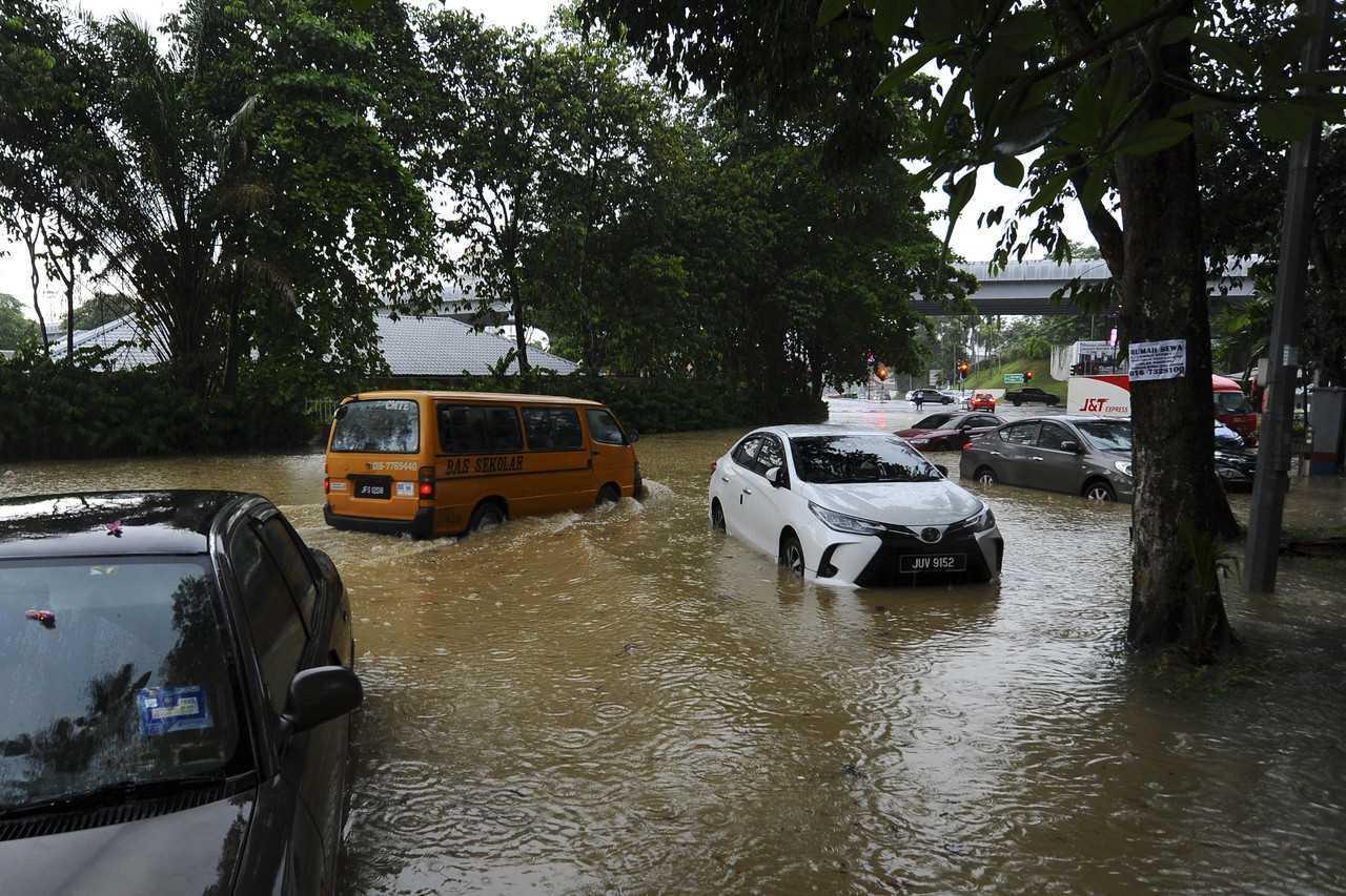 Drivers make their way through the flood waters after flash floods in Jalan Ayer Molek, Johor Bahru yesterday. Photo: Bernama
