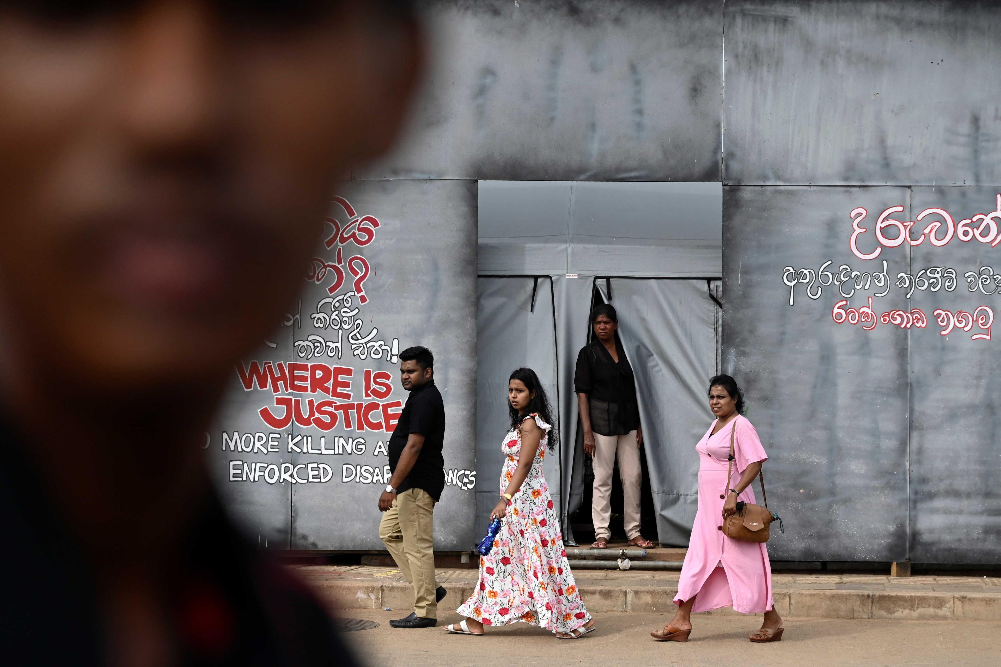 People walk past a mural near Presidential Secretariat in Colombo on July 24. Photo: AFP 