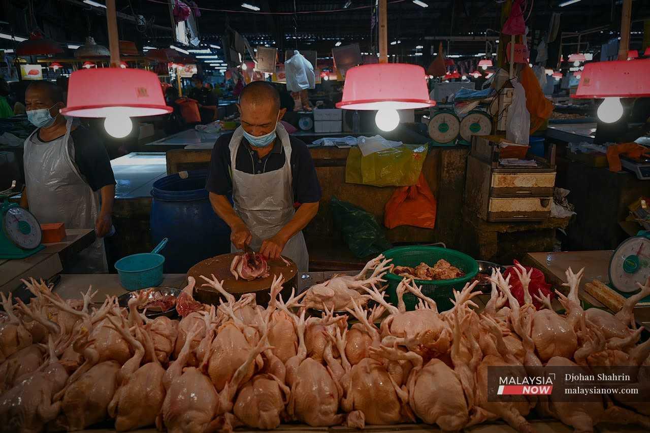 A trader cuts up a chicken at his stall at the Datuk Keramat market in Kuala Lumpur.