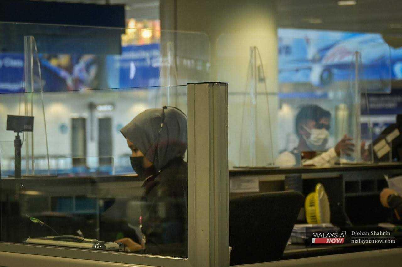 Immigration officers work at their counters at KLIA in Sepang. 