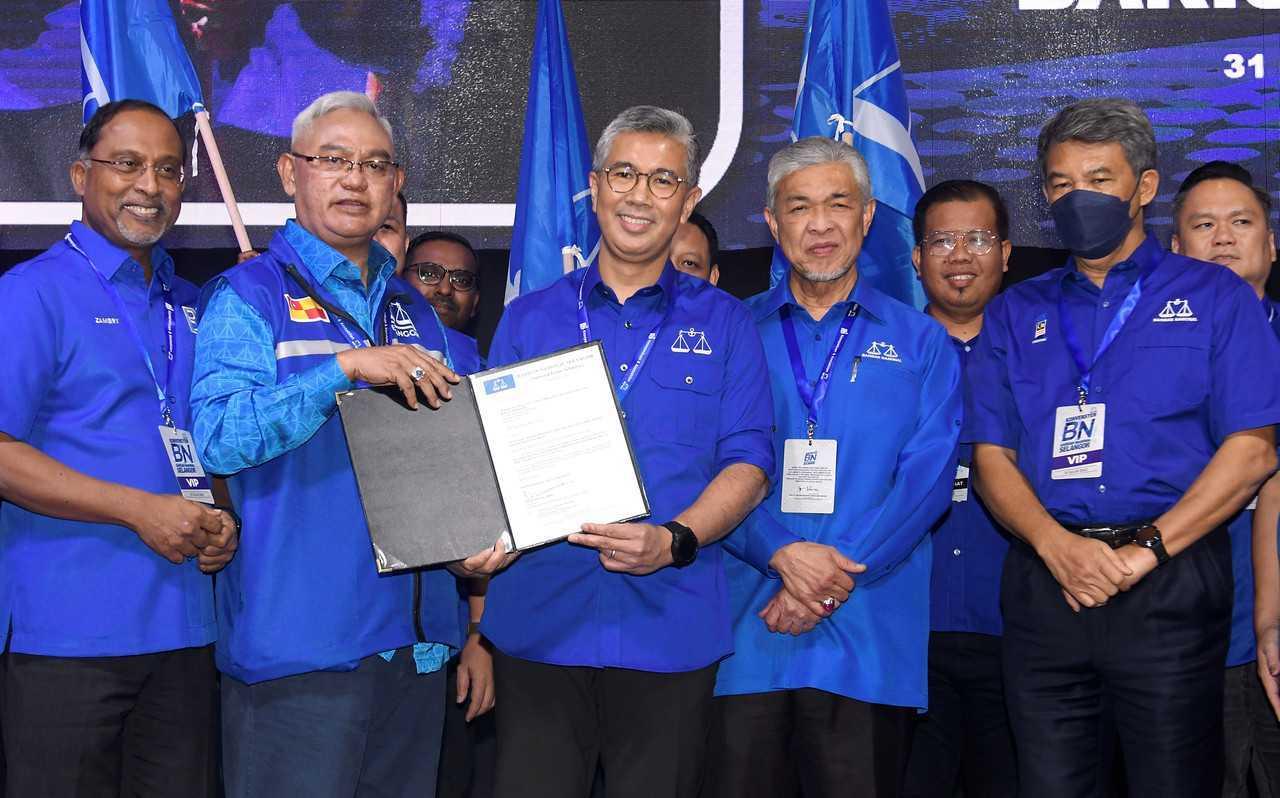 Menteri Kewangan Tengku Zafrul Aziz (tengah) menerima surat lantikan sebagai bendahari Barisan Nasional Selangor sambil diiringi Pengerusi BN Ahmad Zahid Hamidi di konvensyen BN negeri di Shah Alam pada 31 Julai lalu. Gambar: Bernama