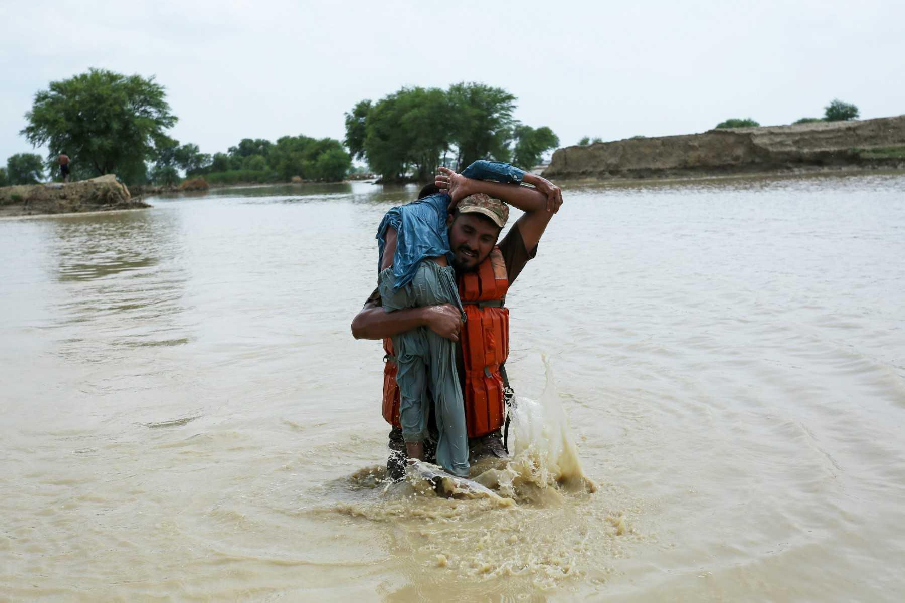 Seorang tentera Pakistan menyelamatkan kanak-kanak daripada banjir yang menjejaskan kawasan Rajanpur, di Punjab, Pakistan pada 2 Ogos lalu. Gambar: AFP