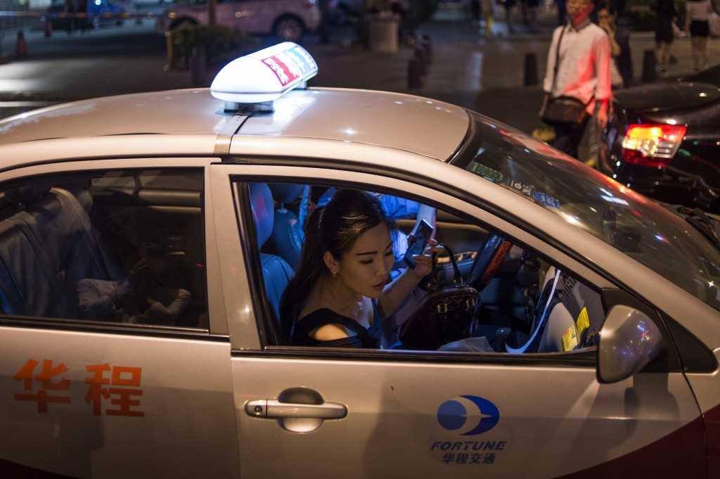 In a picture taken on April 24, 2015, a woman gets into a taxi on a street in the southern Chinese city of Shenzhen. Photo: AFP 