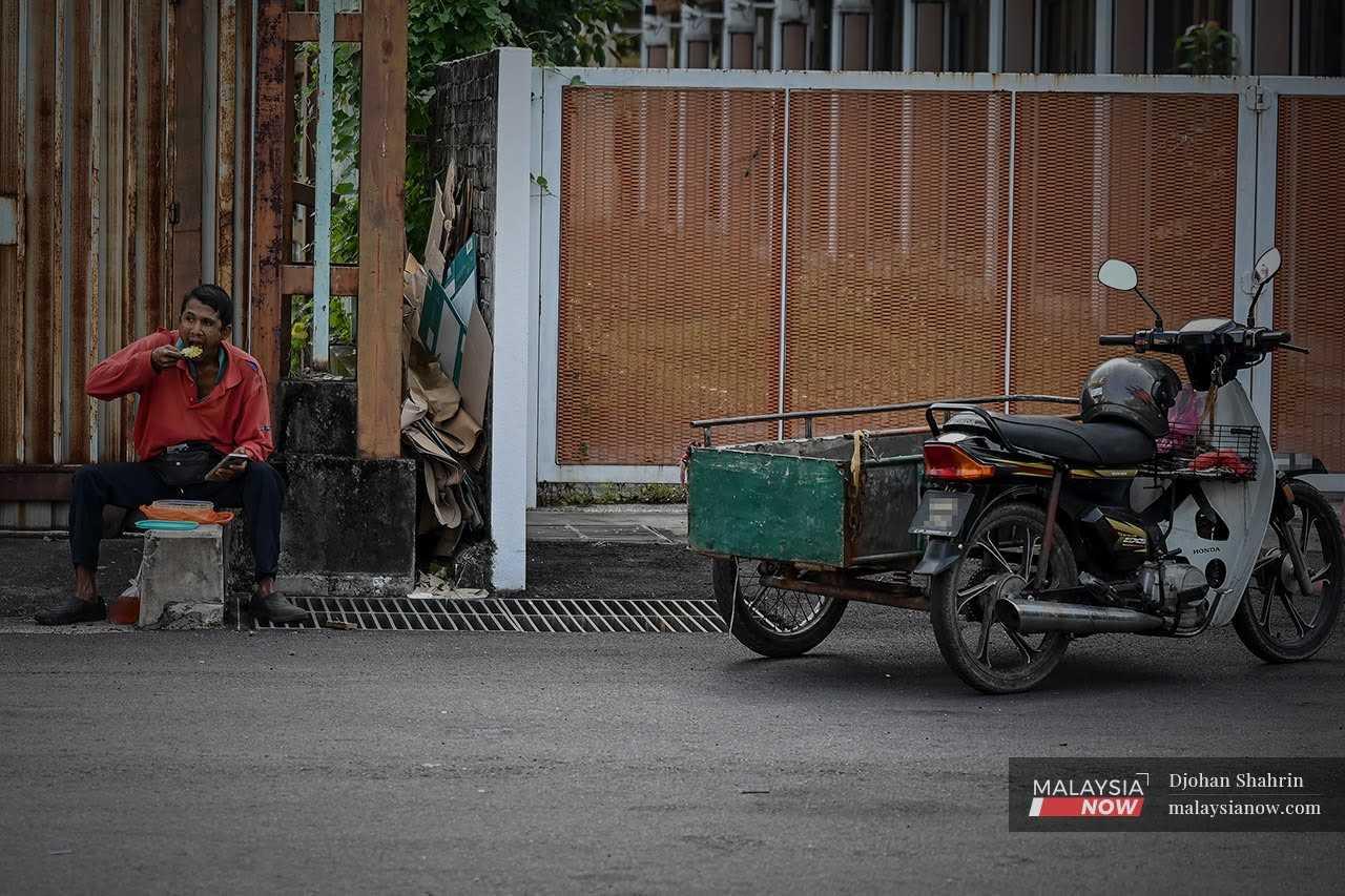 A contract cleaner sits by the side of the road to eat his lunch in this file photo taken in Jalan Chan Sow Lin, Kuala Lumpur. Malaysia is heavily dependent on foreign labour to fill the jobs normally shunned by locals. 

