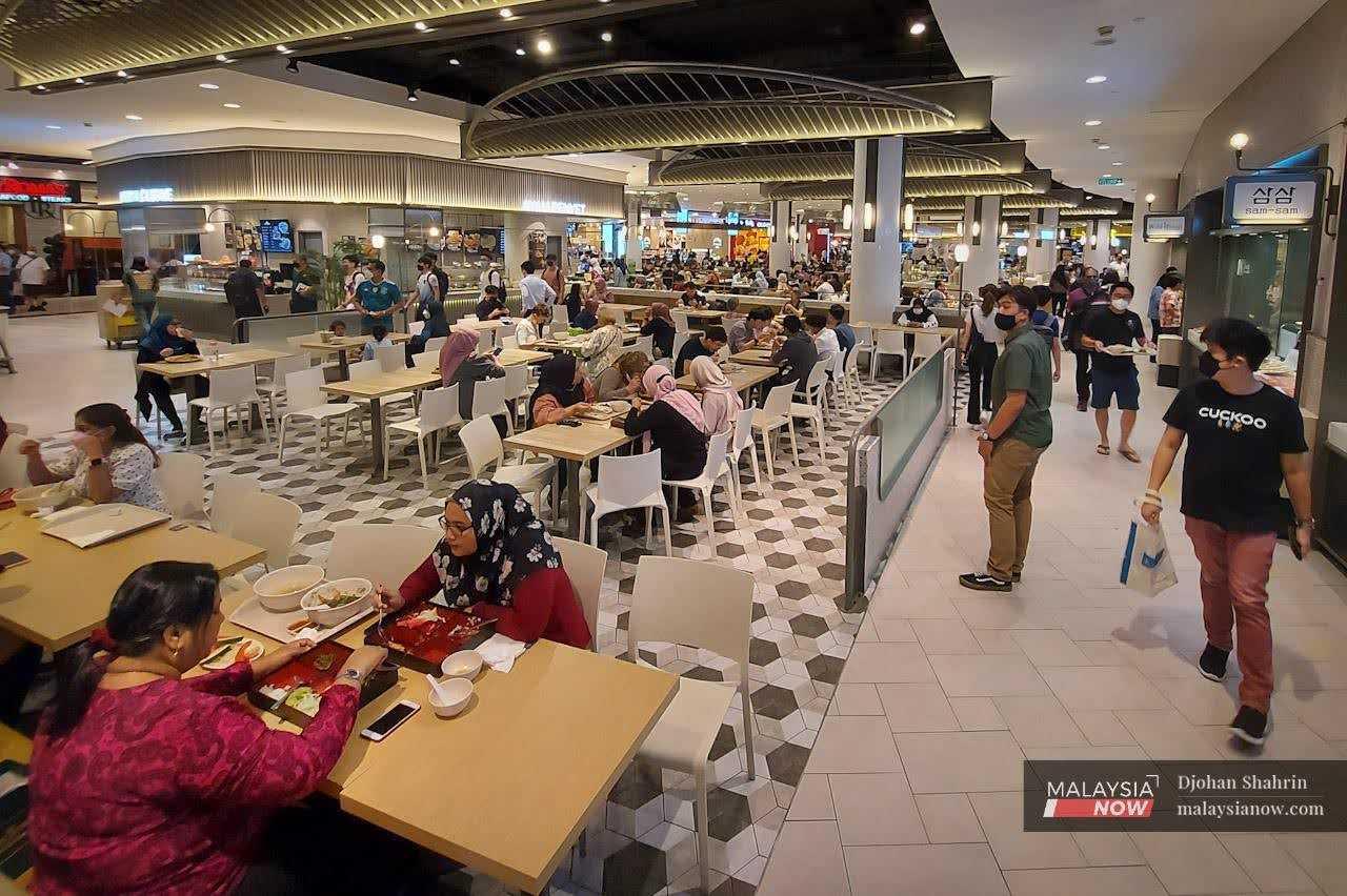 Customers chat as they enjoy lunch at a food court in a mall at Bukit Bintang in Kuala Lumpur.