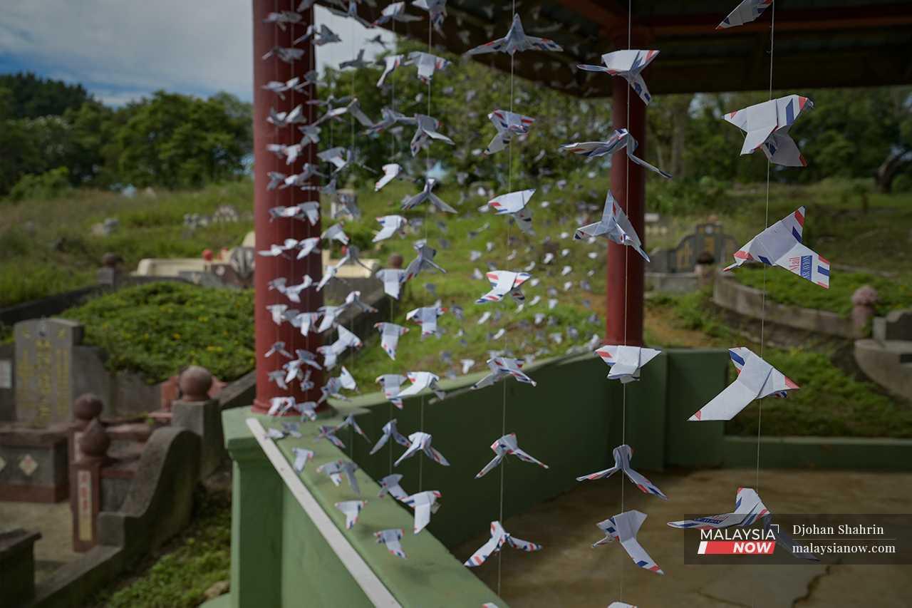 Even this small hut, built as a resting point for those who come to visit the graves, has been hung about with strings of paper birds made out of old envelopes. This simple but effective artwork by Emily Chow Wen Qi is called 'Pigeon Post'.  