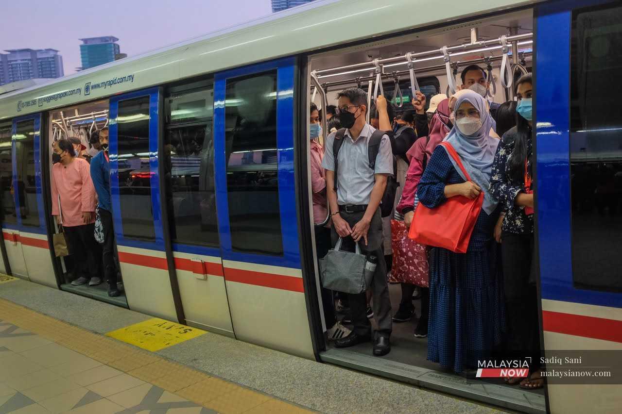 Commuters wearing face masks to curb the spread of Covid-19 take the LRT home from work in Kuala Lumpur.