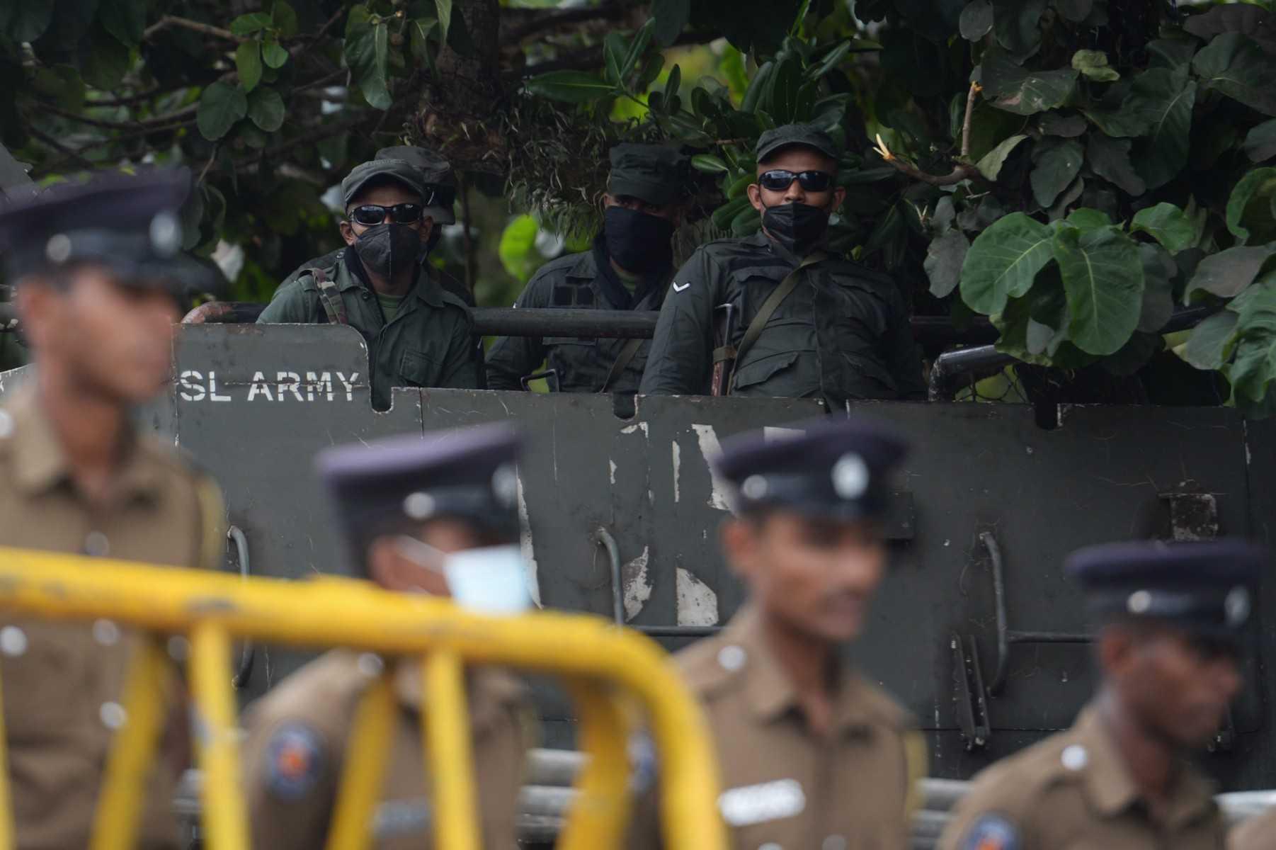 Army personnel and policemen (foreground) stand guard near the Sri Lankan parliament in Colombo on July 20. Photo: AFP