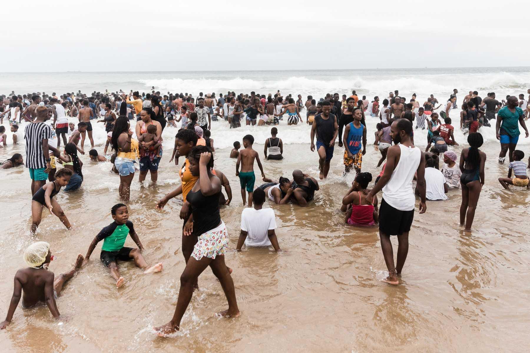 People swim in the ocean along Durban's Golden Mile beach front in Durban on Dec 16, 2021, amidst rising daily Covid-19 cases. Photo: AFP