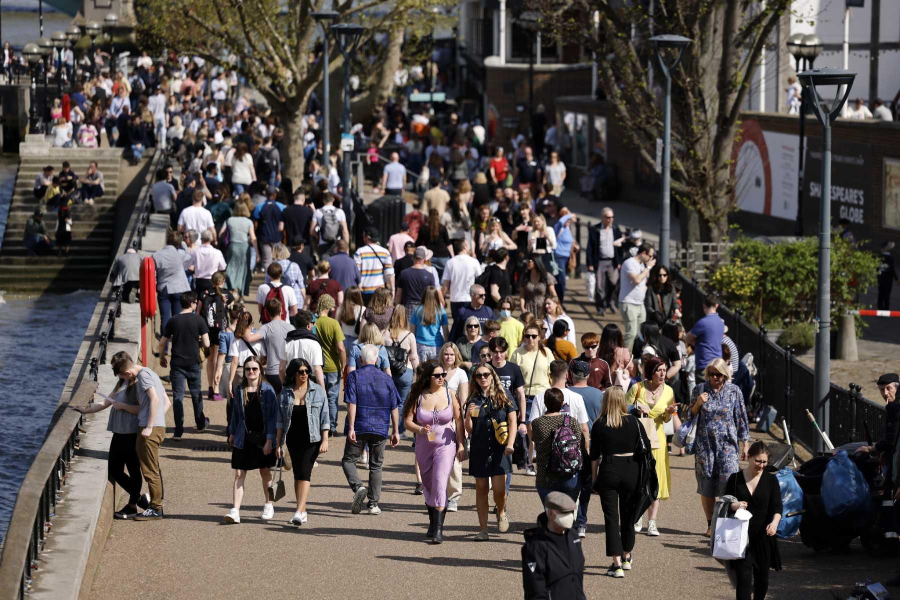 Crowds of people walk in the spring sunshine past Shakespeare's Globe theatre on the south bank of the River Thames in London on April 15. Photo: AFP
