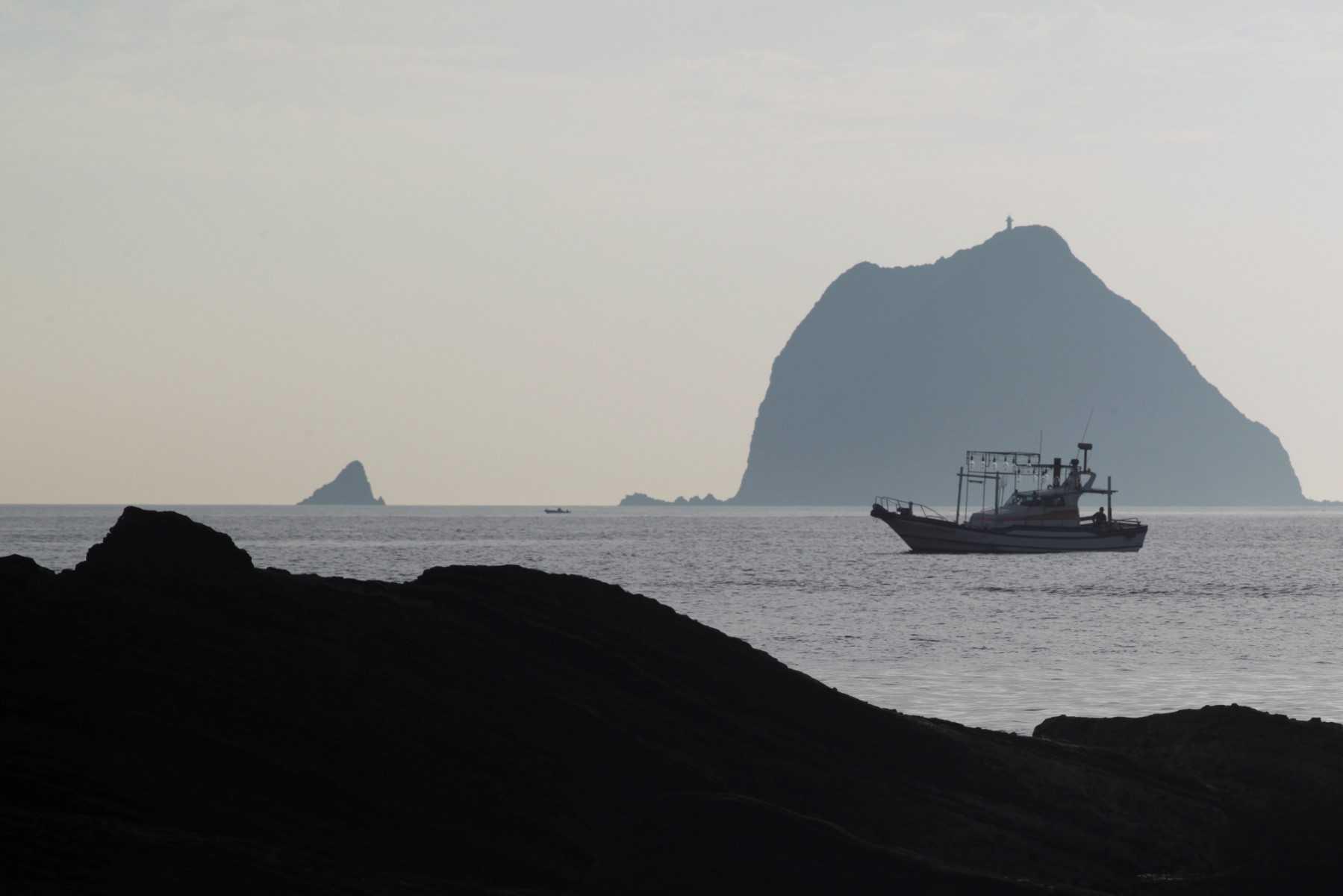 A fishing boat sails pass the Keelung islet near Waimushan on the north coast of the island on June 21. Photo: AFP