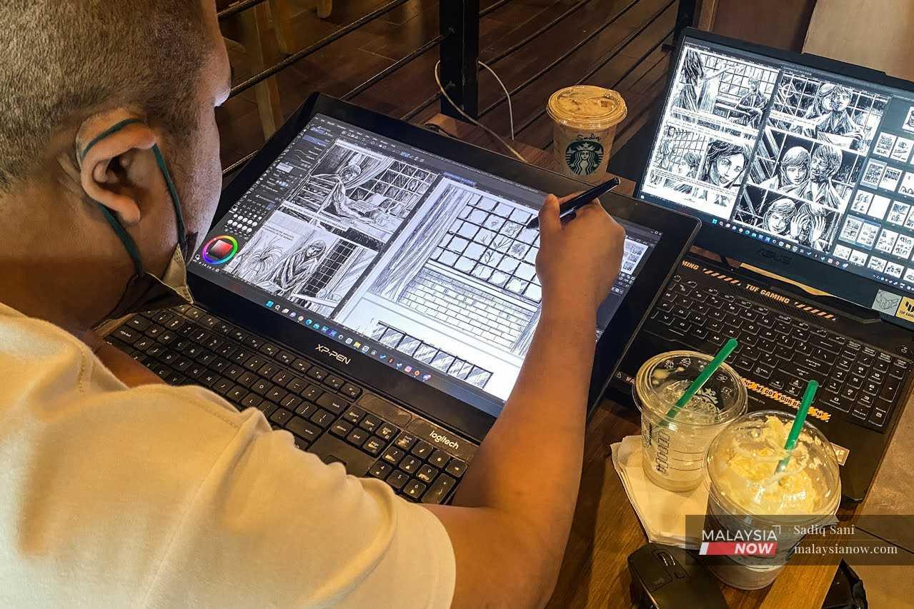 Artis autistik Luqman Hakim sedang tekun menyiapkan projek komiknya di sebuah kafe berdekatan rumahnya.