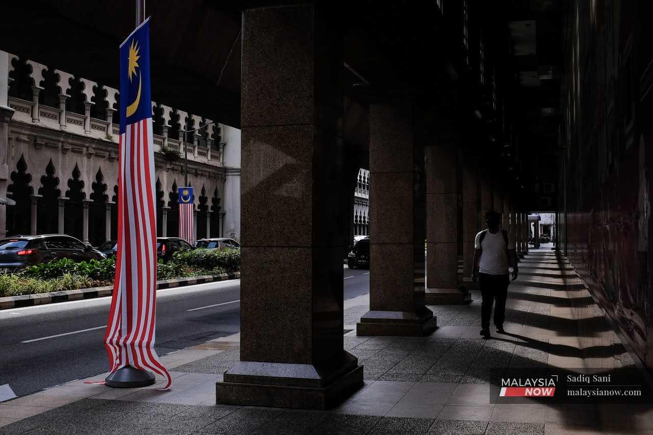 A man walks along the street near Masjid Jamek in Kuala Lumpur.