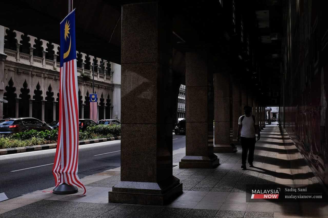 A man walks along the street near Masjid Jamek in Kuala Lumpur. 