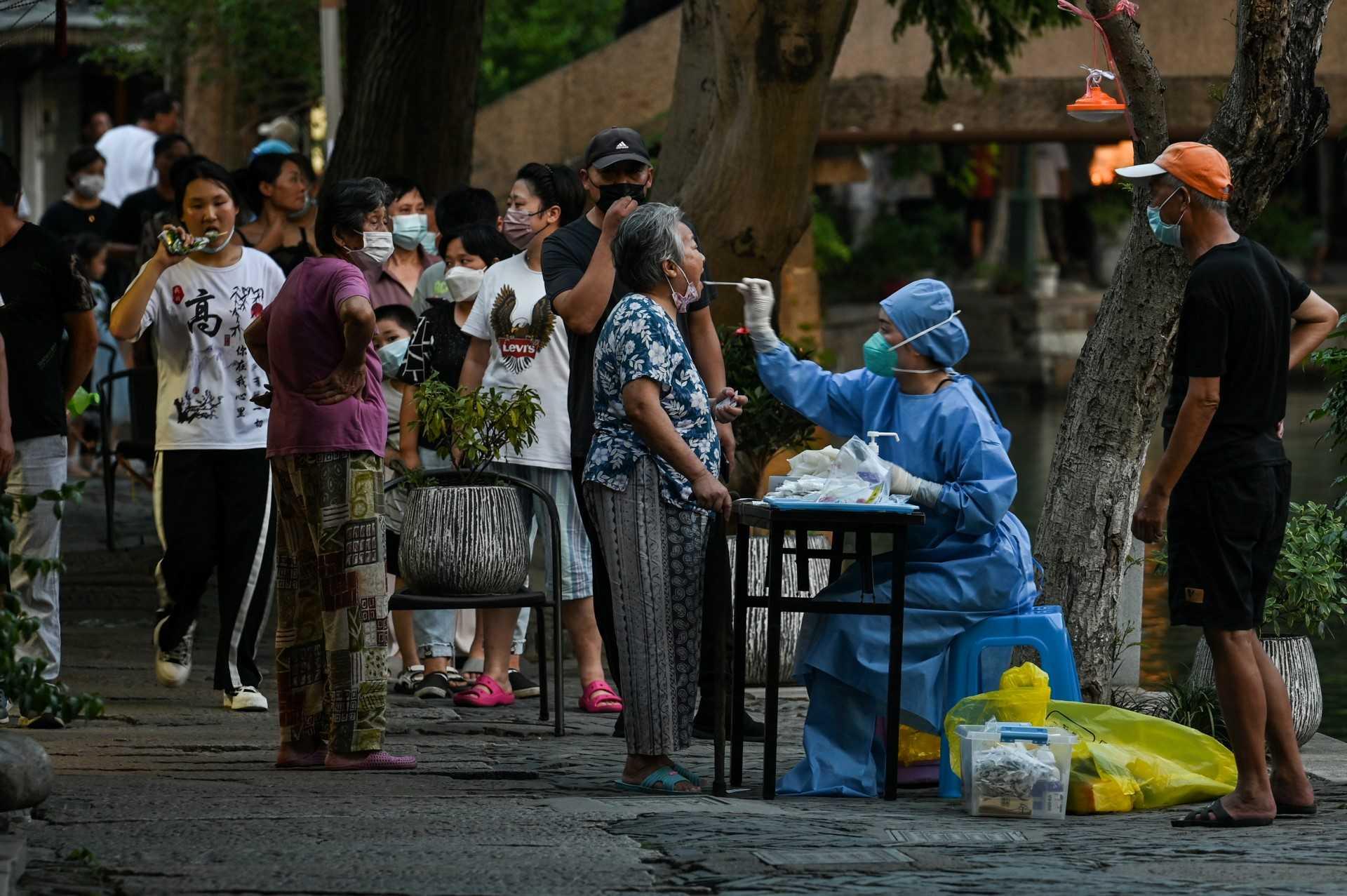 A health worker takes a swab sample from a woman to test for Covid-19 next to a channel in the Zhujiajiao ancient water town in Shanghai, on July 31. Photo: AFP