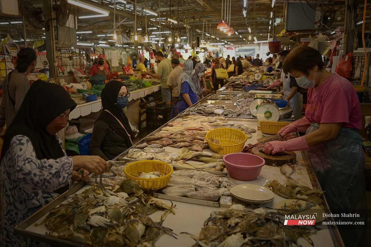 Customers buy fresh seafood and vegetables at the Jalan Chow Kit market in Kuala Lumpur.