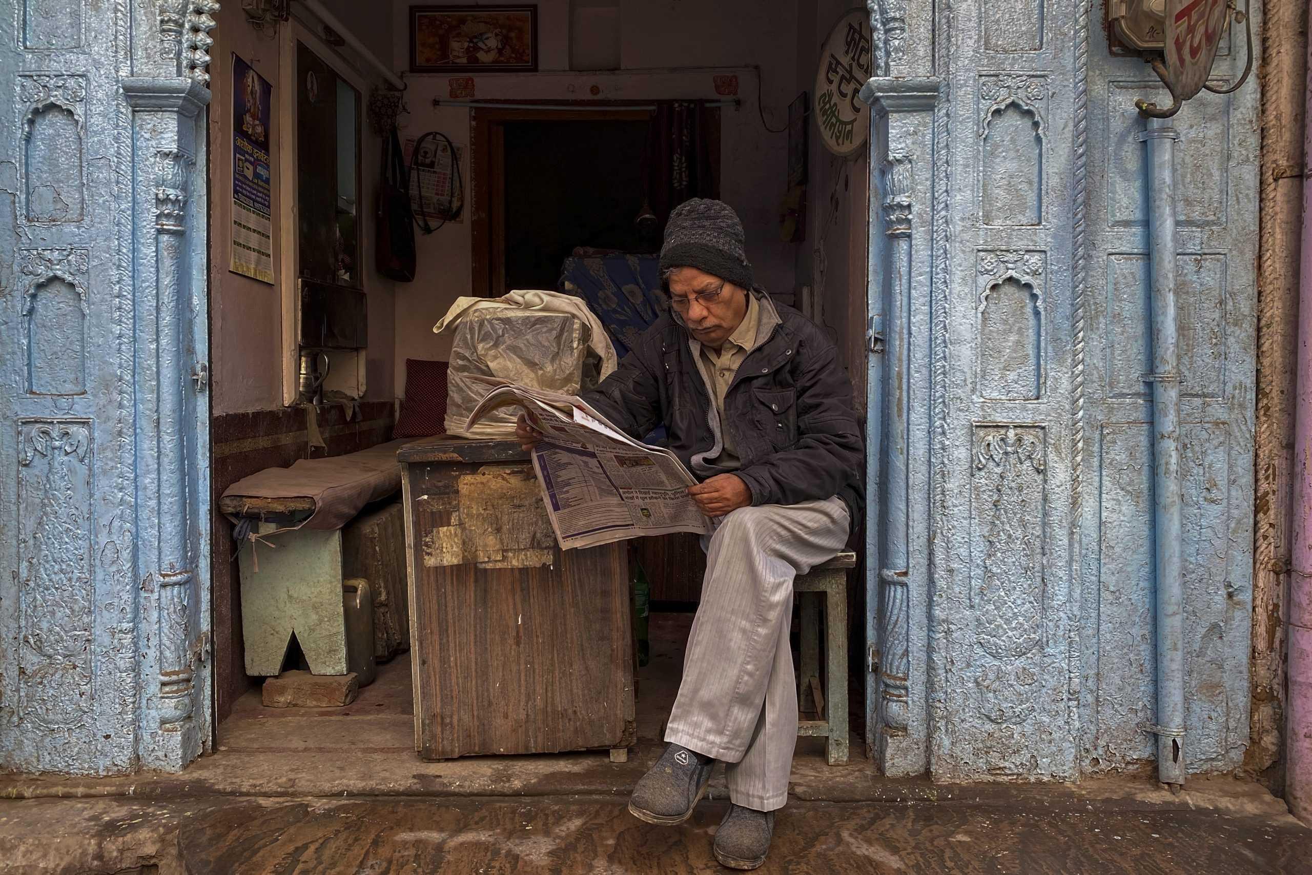 A man reads a newspaper at a shop in Mathura, India, in this Feb 5 photo. Photo: AFP