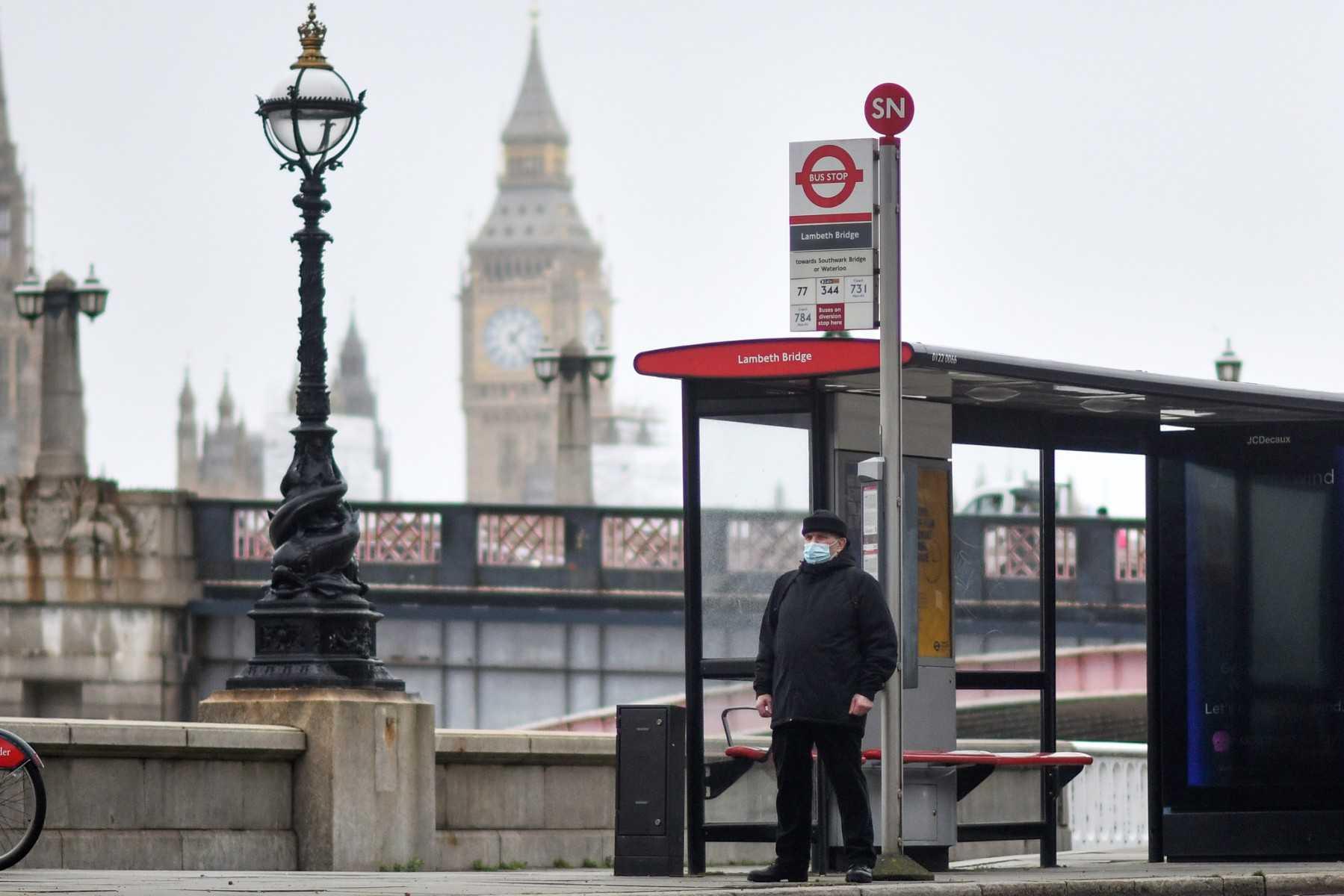 A commuter waits at a bus stop near the Elizabeth Tower, commonly known as Big Ben, at the Palace of Westminster in London on Feb 16. Photo: AFP