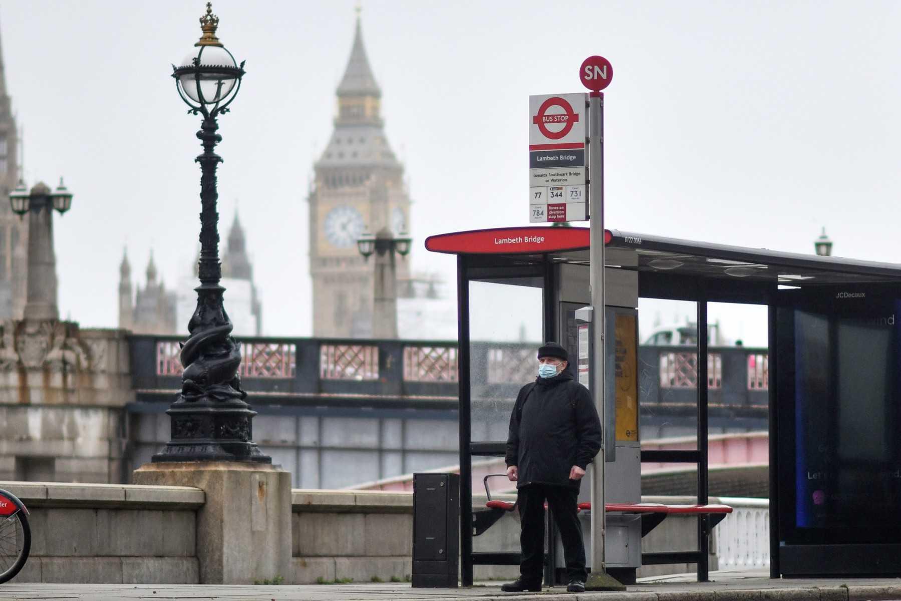 A commuter waits at a bus stop near the Elizabeth Tower, commonly known as Big Ben, at the Palace of Westminster in London on Feb 16.  Photo: AFP 