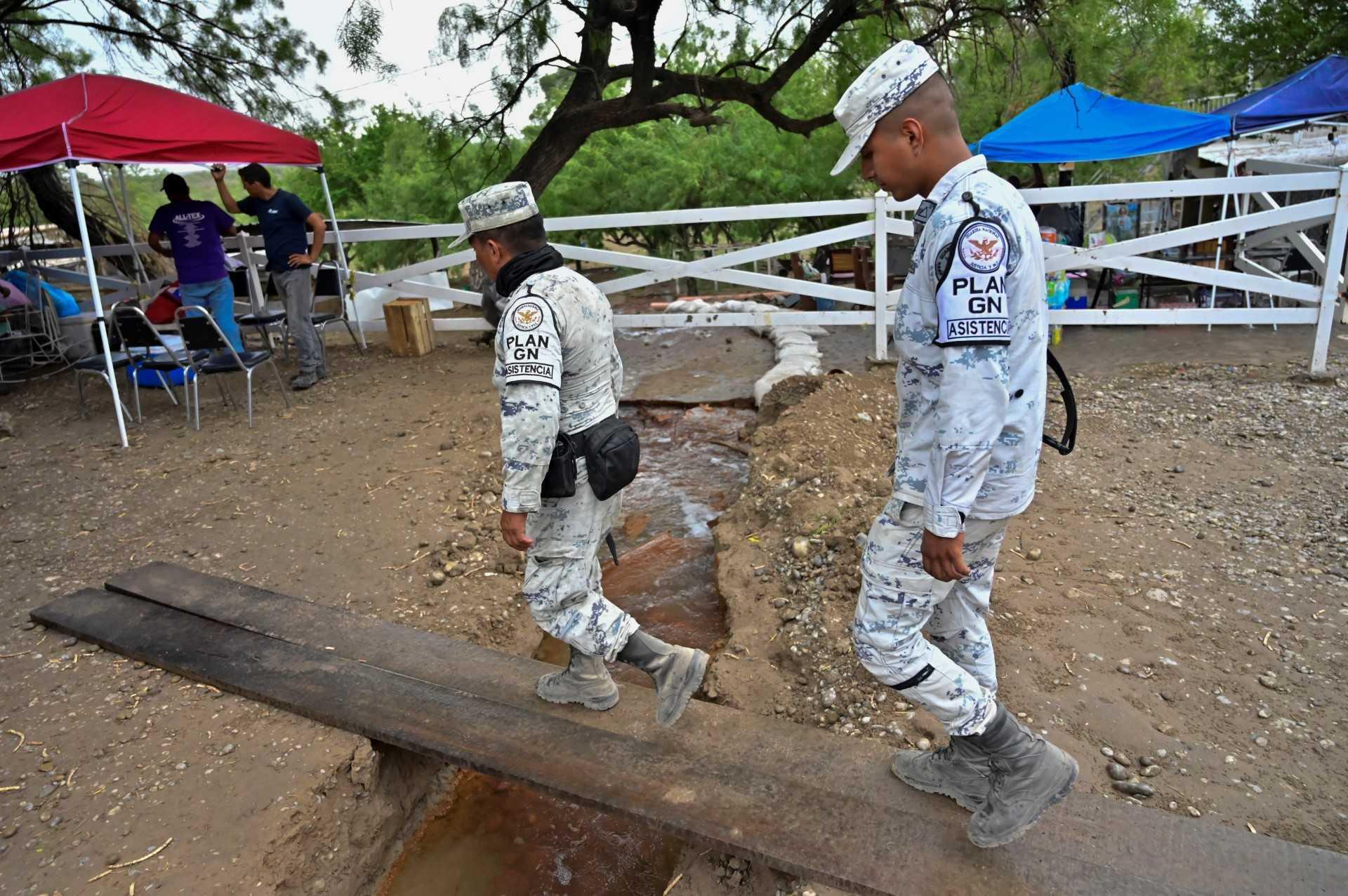 Members of the National Guard walk near the flooded coal mine where 10 miners have been trapped after a landslide, in the community of Agujita, Municipality of Sabinas, Coahuila State, Mexico, on Aug 11. Photo: AFP