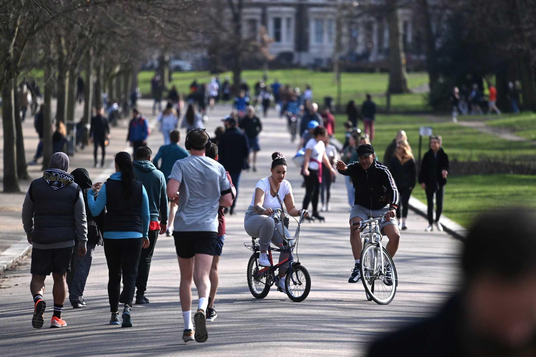 People enjoy the winter sunshine as they take their daily exercise in Victoria Park, east London on Feb 27, 2021. Around 26 million people in Britain are estimated to be eligible for an autumn Covid-19 booster, having had at least two Covid vaccine doses already. Photo: AFP 