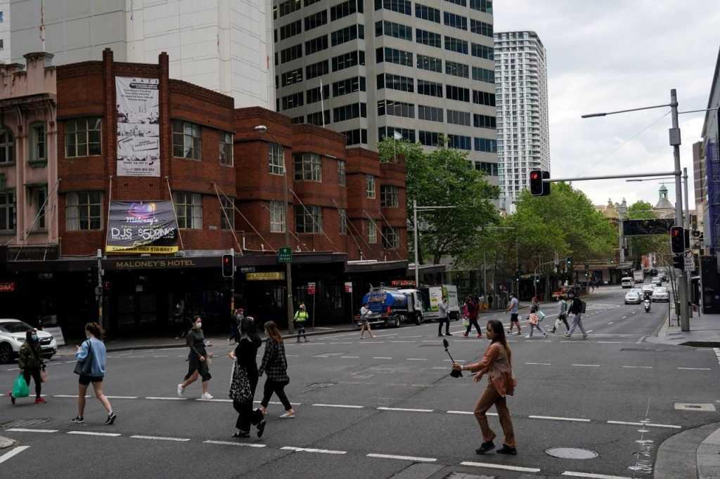 Pedestrians cross at an intersection in the city centre during a lockdown in Sydney, Australia, Sept 28, 2021. Photo: Reuters