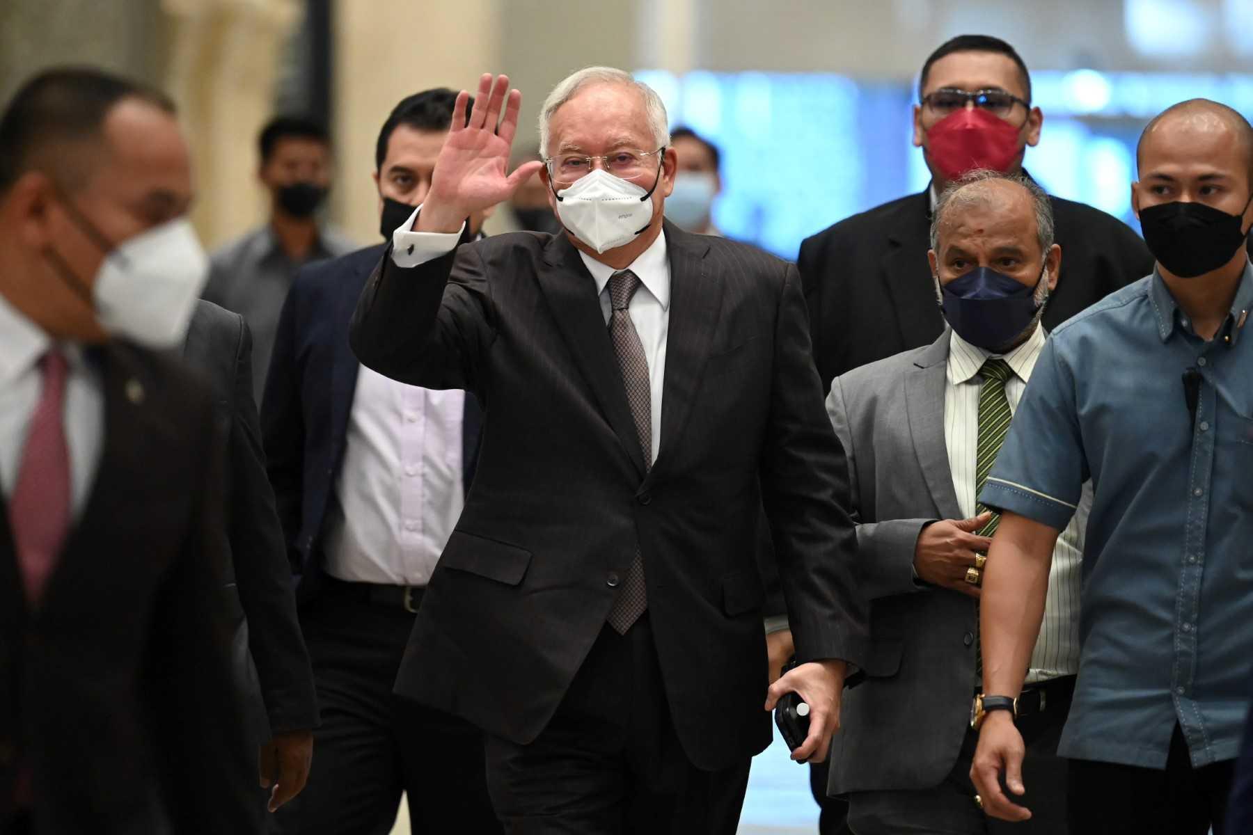 Bekas perdana menteri Najib Razak (tengah) melambaikan tangannya ketika tiba di Mahkamah Persekutuan Putrajaya hari ini. Gambar: AFP