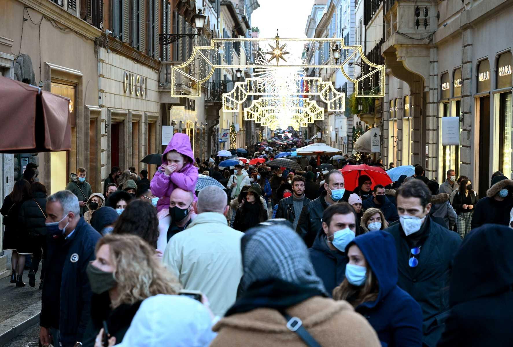 Orang ramai memakai pelitup muka ketika berjalan di Via Condotti, sebuah pusat beli-belah mewah di Rome pada Disember 2021. Gambar: AFP