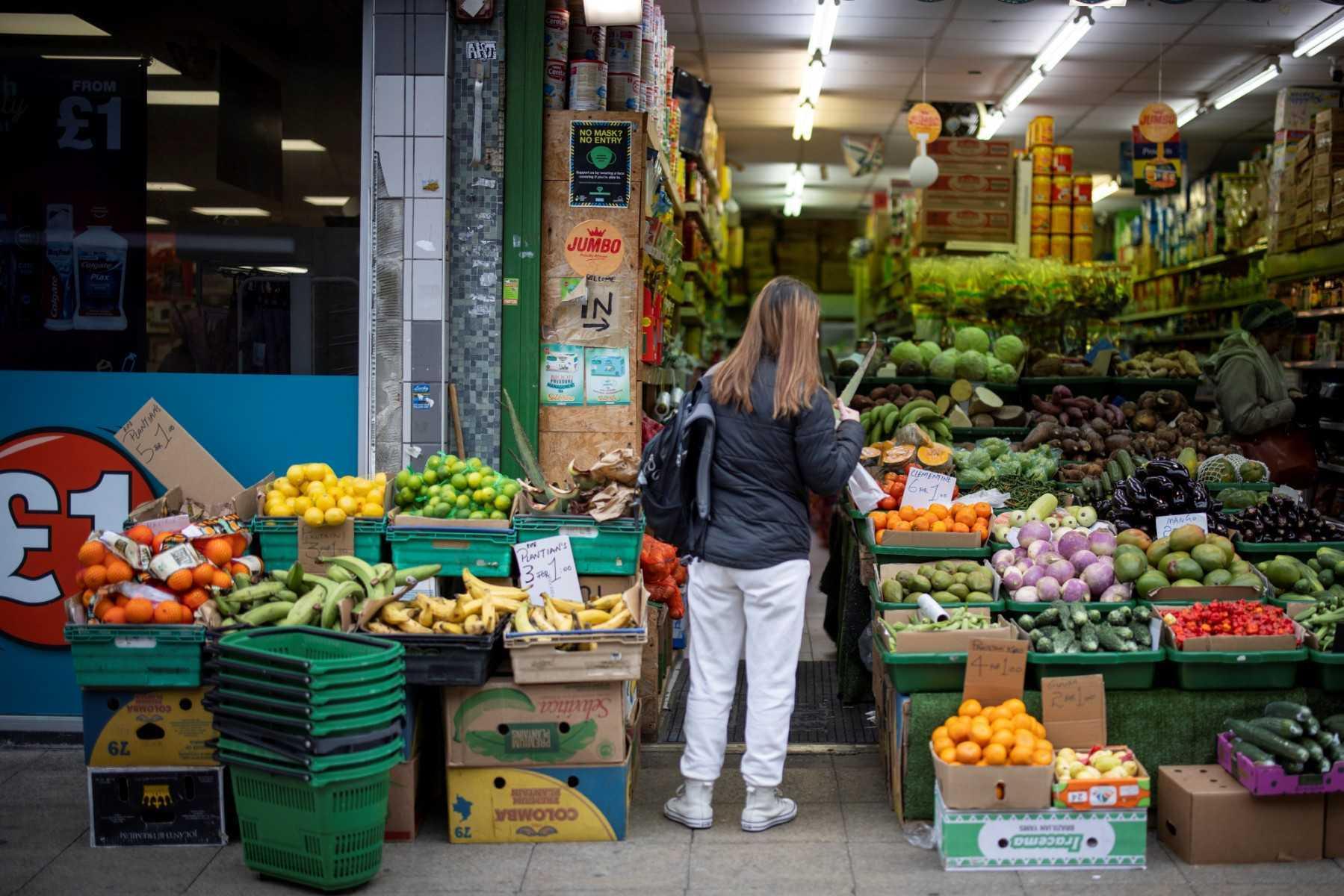 A customer shops for fruit and vegetables at a greengrocer's shop in Walthamstow, east London on Feb 13. Photo: AFP