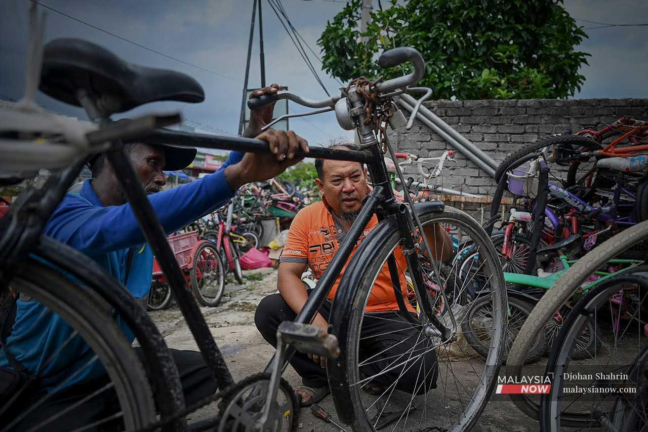 Mohd Kamal Jusop examines a bicycle brought to his workshop in Hulu Langat, Selangor.