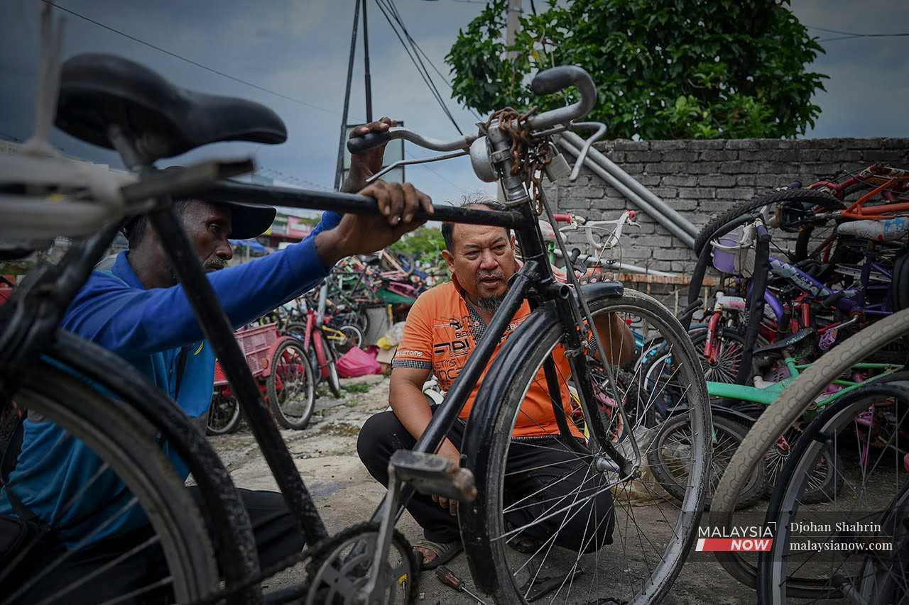 Mohd Kamal Jusop examines a bicycle brought to his workshop in Hulu Langat, Selangor. 
