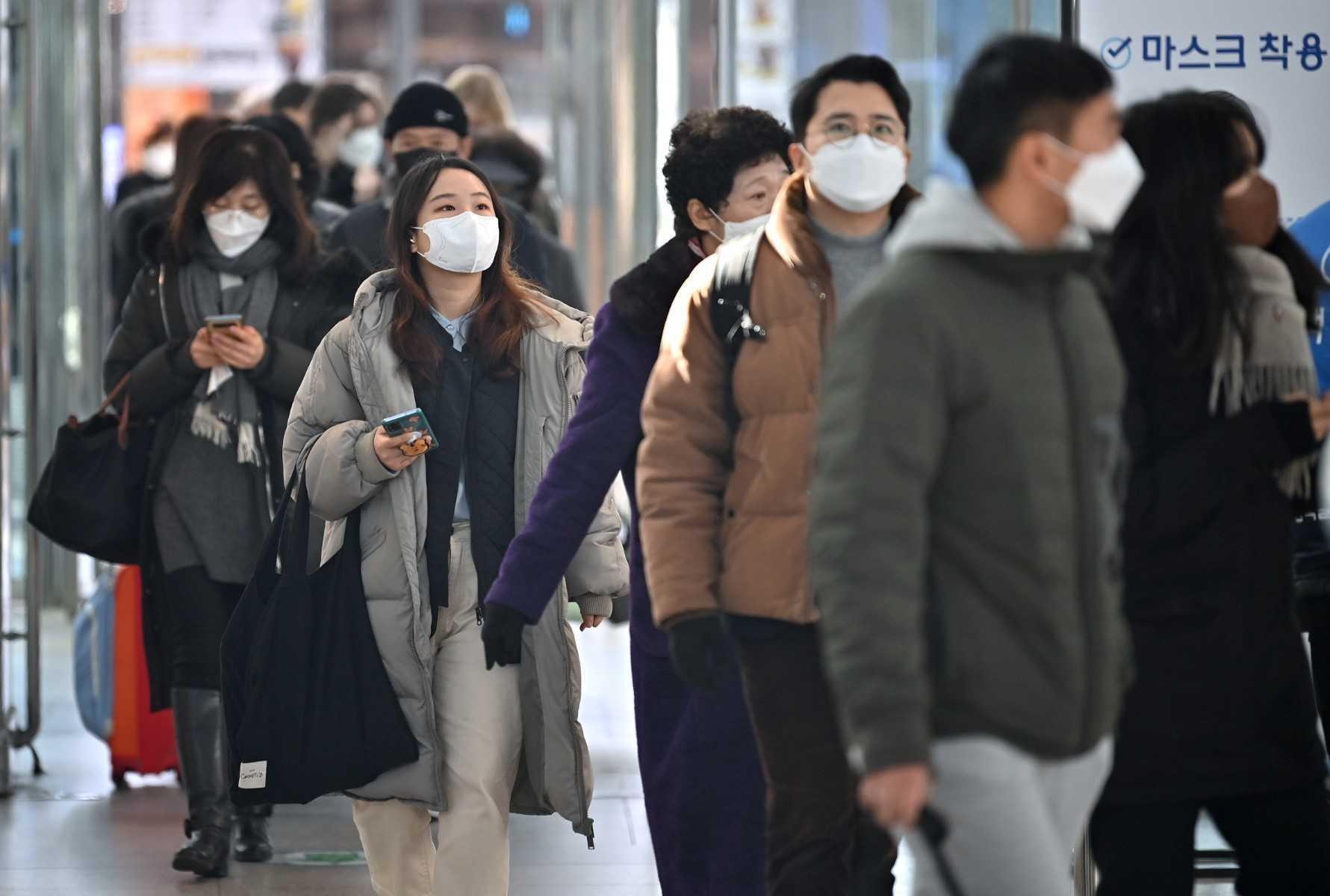 Orang ramai memakai pelitup muka ketika berjalan di stesen kretapi di Seoul pada 18 Februari 2022. Gambar: AFP